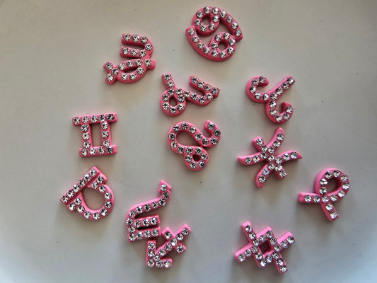 Set completo de 12 signos zodiacales decorativos para nail art en color rosa con cristales brillantes sobre fondo blanco, mostrando todos los símbolos astrológicos: Aries, Tauro, Géminis, Cáncer, Leo, Virgo, Libra, Escorpio, Sagitario, Capricornio, Acuario y Piscis organizados en tres filas

